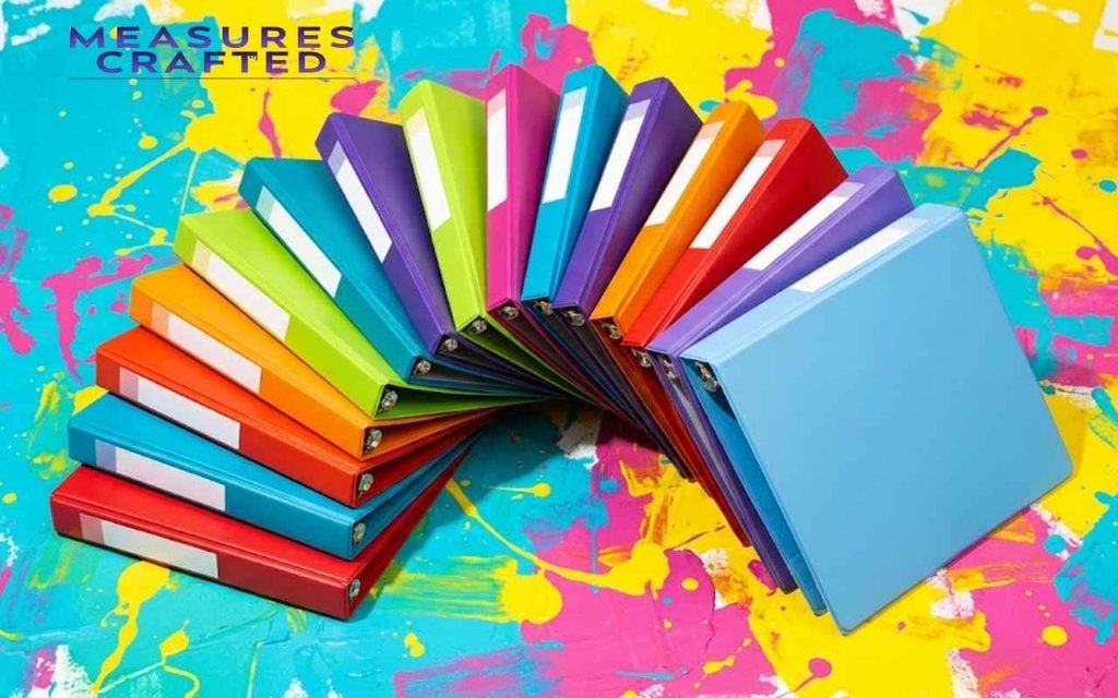 11 inches colorful binders arranged in a semi-circle fan. A white background with vibrant paint splatters.