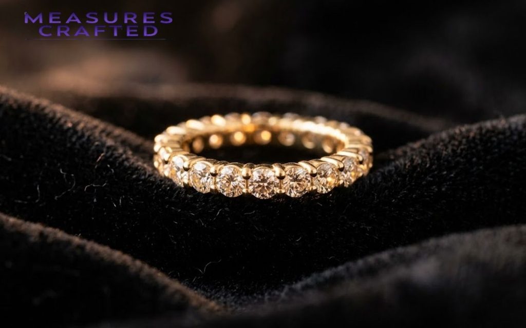 Diamond eternity ring in yellow gold resting on soft black velvet.